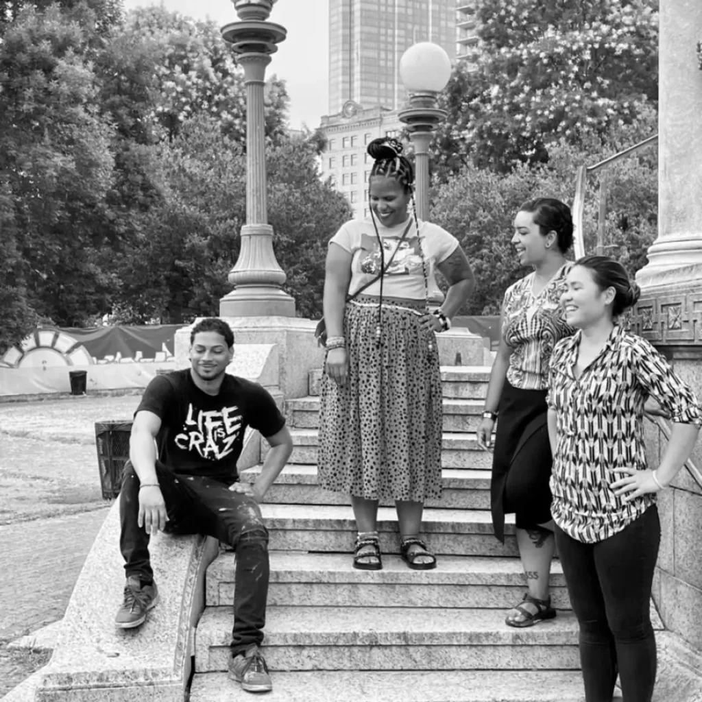 People posed standing and sitting on some outdoor stairs.