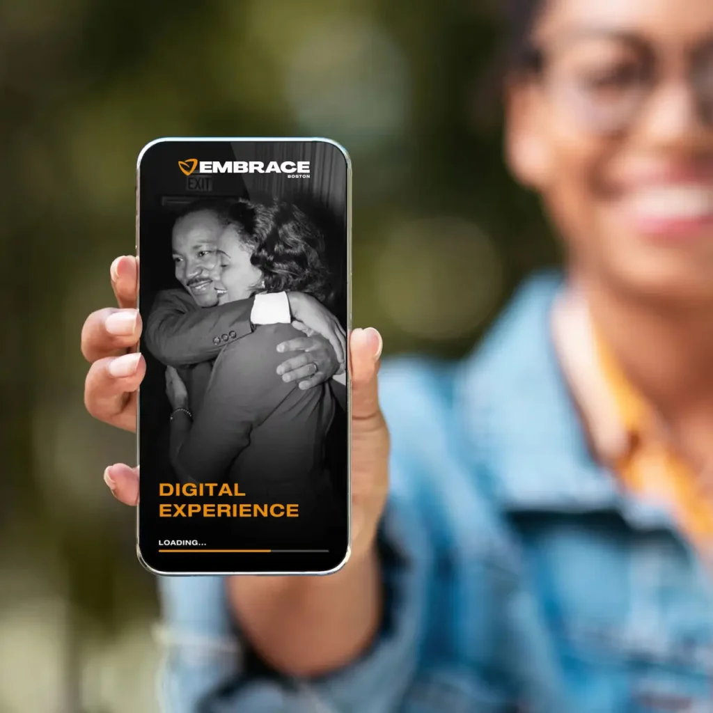 Phone in focus showing Embrace website mockup